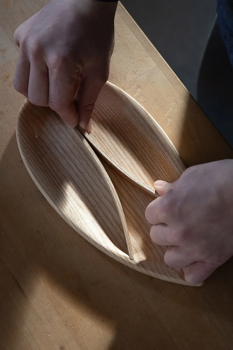 Steam-bent wooden desk tray in oak, overhead view showing the teardrop form and three compartments