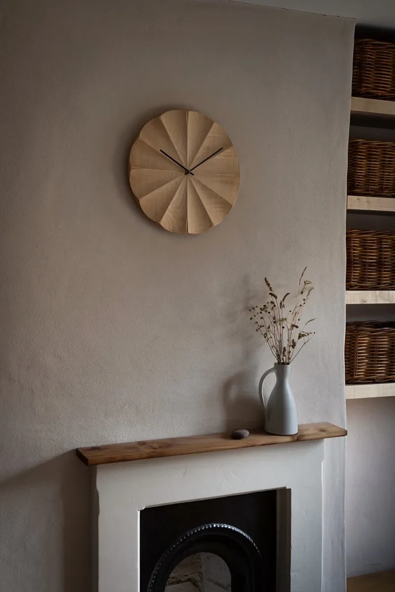 Fluted sycamore wall clock hanging on a wall