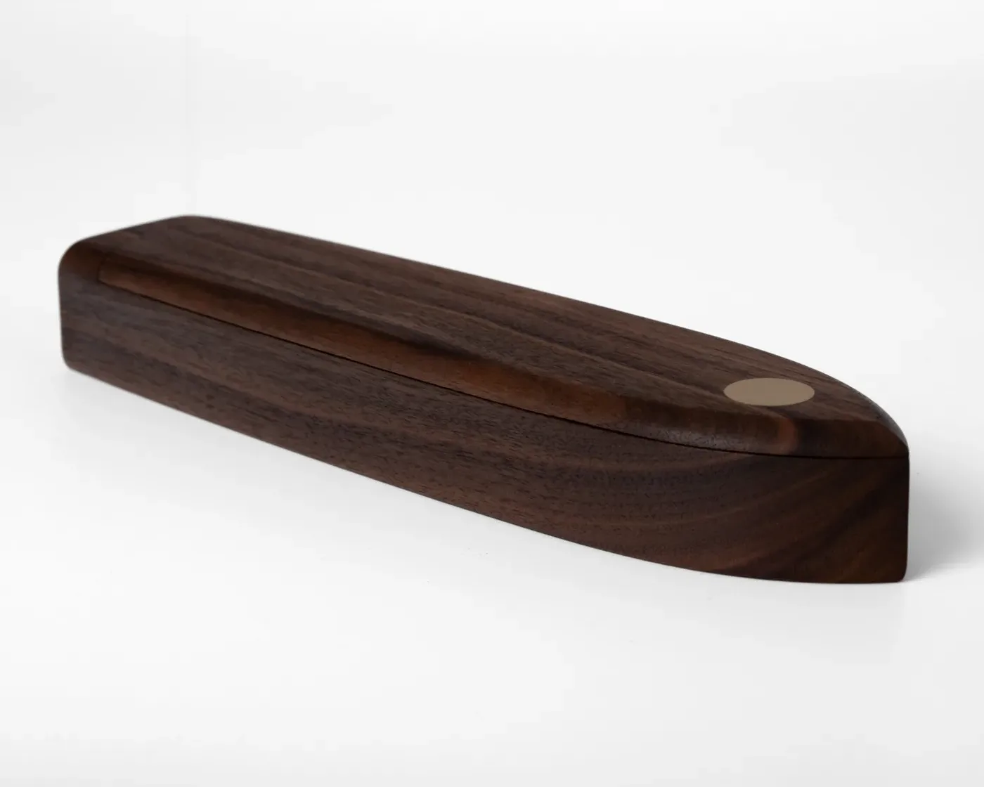Walnut pen box with lid slightly open, showing the grain and brass pivot inlay