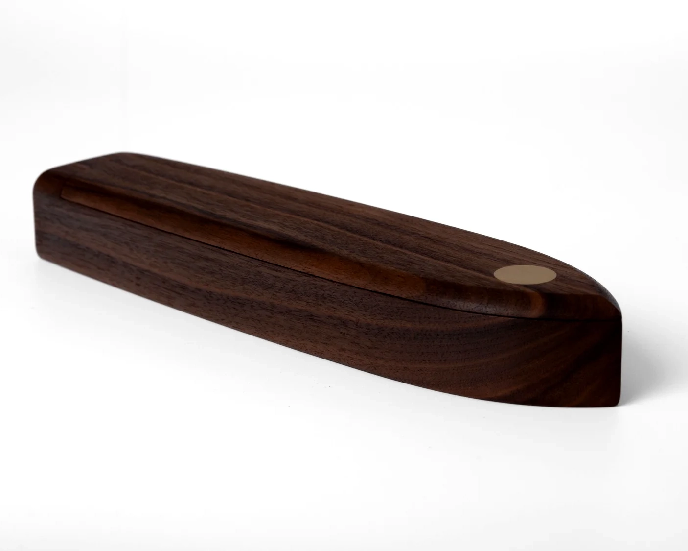 The Lapwing pen box in British walnut, full side profile showing the boat-inspired form and grain